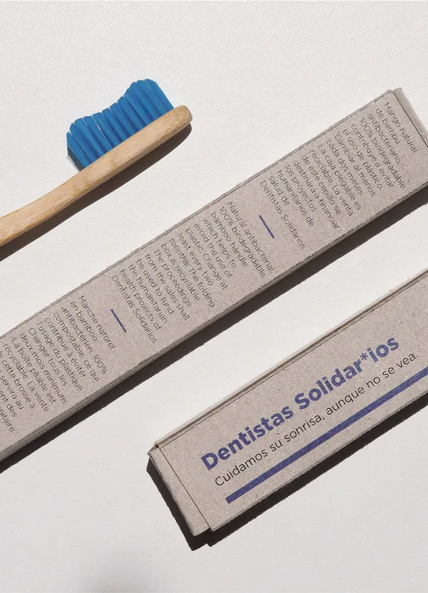 Trees standing on a mountain hill with mountains and a blue sky with some clouds in the background.
